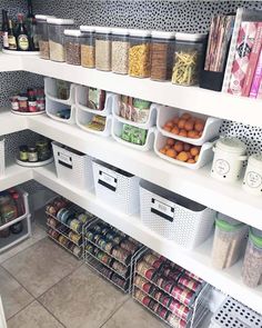 an organized pantry with bins, containers and food on the shelves in front of them