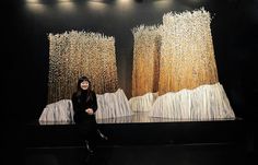 a woman sitting in front of two large paintings