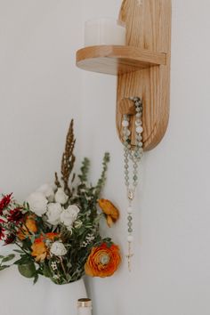 a vase filled with flowers next to a wooden shelf