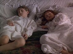 two children are sleeping on a bed together