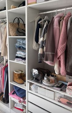 an organized closet with clothes, shoes and handbags on the shelve shelves