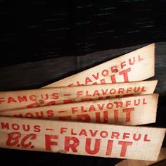 three wooden signs that say famous fruit and have red lettering on the bottom one says famous fruit