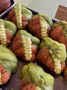 there are many green and red pastries on display