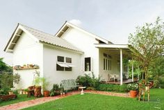 a white house sitting on top of a lush green field