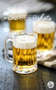 two mugs filled with beer sitting on top of a table