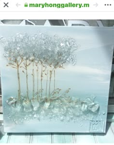 a painting on glass with flowers and rocks in the foreground, against a white background