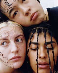 three young women with their eyes closed and hair curled up in the shape of hearts