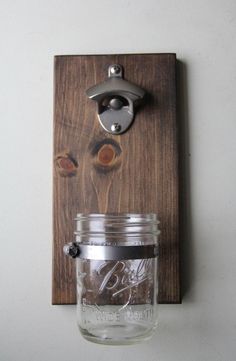 a mason jar hanging on a wall with a metal hook