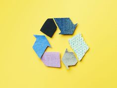 four pieces of fabric laid out in the shape of an origami fish on a yellow background