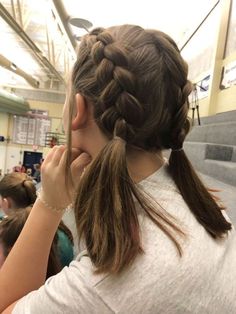 a girl with long hair braided into a pony tail