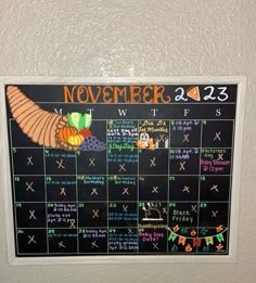 a chalk board with the calendar for november and december written in orange, green, and blue