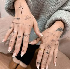 two women's hands with tattoos on them