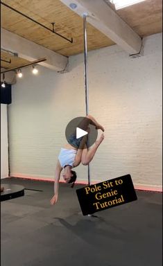 a person is hanging upside down on a pole in an empty room with a sign that says pole sit to genie turoria