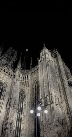 an old cathedral lit up at night with street lights