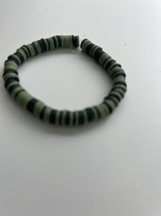 Green and black clay bead bracelet Green And Black Bracelet, Clay Bead Bracelet Ideas For Men, Black Heishi Beads Bracelet, Black Heishi Beads Beaded Bracelets, Black Heishi Beads Jewelry For Friendship, Handmade Black Heishi Beads Stretch Bracelet, Black Beaded Friendship Bangle Bracelet, Black Beaded Bangle Bracelets For Friendship, Black Beaded Bracelet With Round Beads