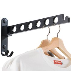 a t - shirt is hanging on a rack with two clothes hangers in front of it