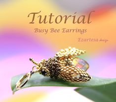 a close up of a brooch on a leaf with the words'tutor busy bee earrings '