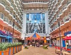 the inside of a cruise ship with many tables and umbrellas in front of it