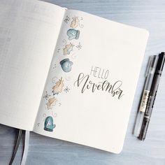 an open notebook with the words hello november written in cursive writing on it