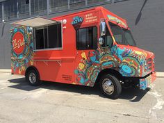 an orange food truck parked in front of a building