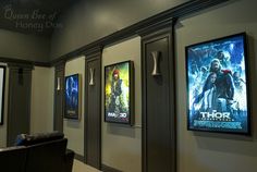 the movie posters are hanging on the wall next to the chairs in the theater room