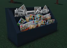 a box filled with newspapers sitting on top of a green field