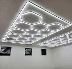 an empty room with white walls and square ceiling tiles on the ceiling is lit by leds