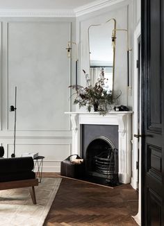 a living room with a fireplace and mirror