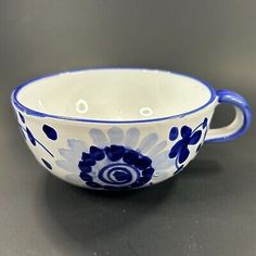 a blue and white bowl sitting on top of a gray table next to a black surface