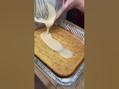 someone pouring batter on top of a cake in a pan