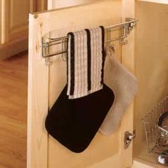 a pair of socks hanging from a towel rack in a kitchen with the door open