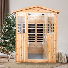 a wooden sauna in the middle of a living room with a christmas tree behind it