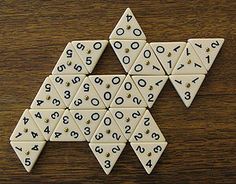 a wooden table topped with white and black dominos on top of a brown surface