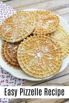 three waffles on a white plate covered in powdered sugar and sprinkled with icing