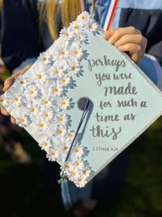 a person holding up a graduation cap with daisies on it that says perhaps you were made for such as this