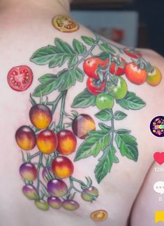 the back of a woman's shoulder with tattoos on it, painted with fruit and leaves