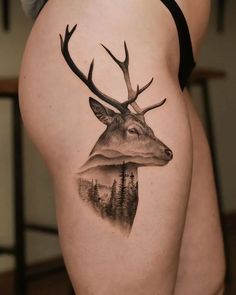 a woman's thigh with a deer tattoo on it