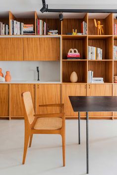 a chair and table in front of a bookshelf