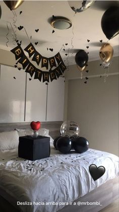 a bedroom decorated for a birthday with balloons and streamers on the ceiling, black and white decor