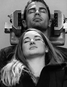 a man laying down next to a woman with her eyes closed in front of him