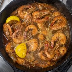 shrimp and lemon are cooking in a pan on the stove