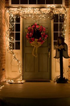 a front door decorated with christmas lights and wreath