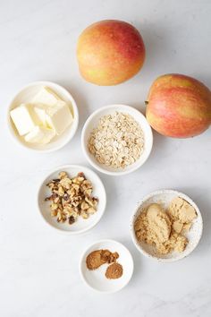 apples, oatmeal, and other ingredients are arranged on a white surface