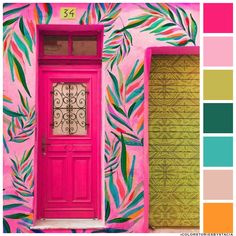 a bright pink door is in front of a colorful wall with palm leaves painted on it