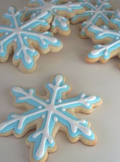 decorated cookies with blue and white icing on a table