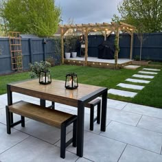 a wooden table sitting on top of a white tile floor next to a park bench