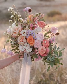 a woman holding a bouquet of flowers in her hand