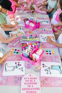 there are many children sitting at the table making crafts and decorating them with watercolors