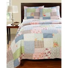 a bed covered in a colorful patchwork quilt