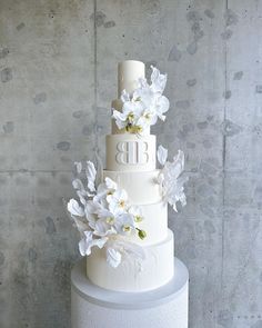 a three tiered cake with white flowers on top